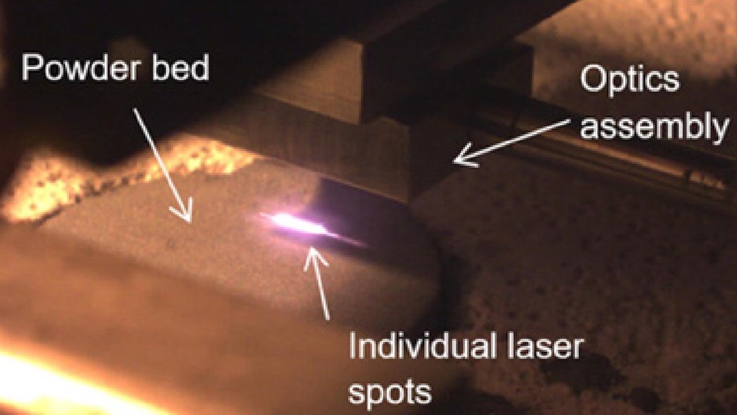 Image from the journal paper Laser diode area melting for high speed additive manufacturing of metallic components showing the actual melting beam of the diode bar on the powder bed during DAM - Image from the journal paper Laser diode area melting for high speed additive manufacturing of metallic components showing the actual melting beam of the diode bar on the powder bed during DAM